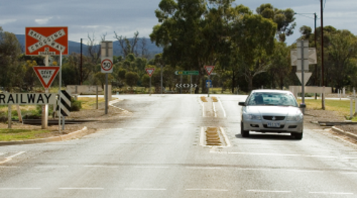 A front on shot of a car passing through a level crossing